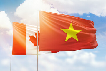 Sunny blue sky and flags of vietnam and canada