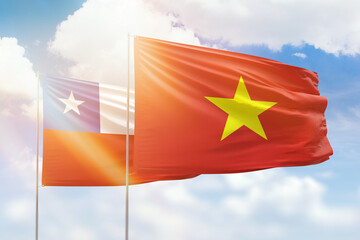 Sunny blue sky and flags of vietnam and chile