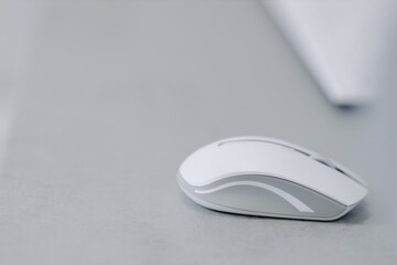 White bluetooth mouse for computer on a gray table