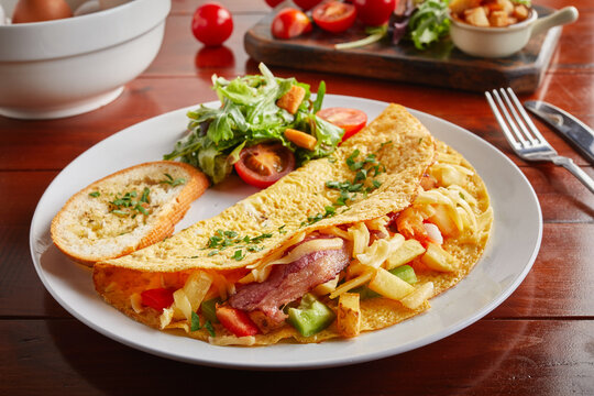 Hash Gouda omelette roll with salad served in a dish isolated on wooden background side view