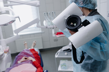 A female dentist prepares to photograph the patient's teeth before the teeth whitening procedure....