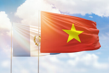 Sunny blue sky and flags of vietnam and guatemala
