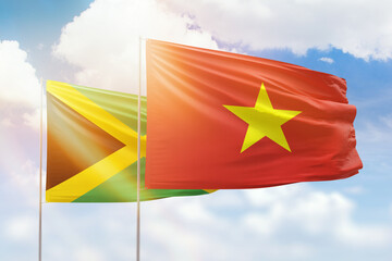 Sunny blue sky and flags of vietnam and jamaica