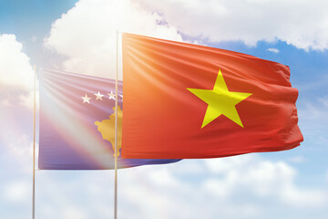 Sunny blue sky and flags of vietnam and kosovo