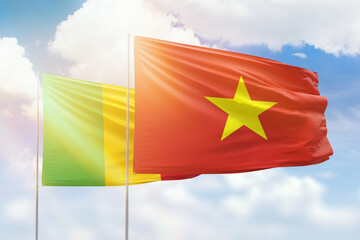 Sunny blue sky and flags of vietnam and mali