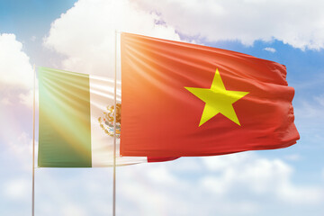 Sunny blue sky and flags of vietnam and mexico