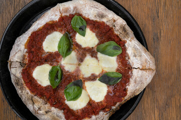 Sourdough pizza. Closeup view of a pizza with tomato sauce, boconccinos cheese and fresh basil leaves.