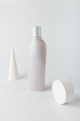 Hair conditioner or shampoo bottle on white background. Care cosmetics, concrete decor. Mock up, blank template, no brand, no label