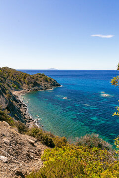 High angle view over Ogliera beach, a little wild free beach with dark sand, rocks and stones near Pomonte perfekt for snorkeling and deep sea diving to a shipwreck