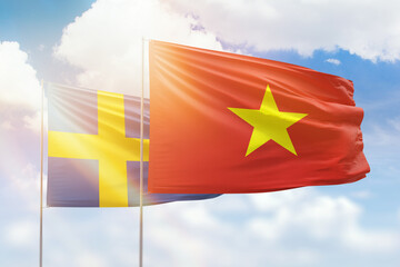 Sunny blue sky and flags of vietnam and sweden