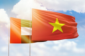 Sunny blue sky and flags of vietnam and uae