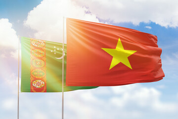 Sunny blue sky and flags of vietnam and turkmenistan