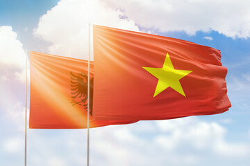 Sunny blue sky and flags of vietnam and albania