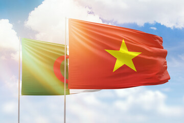 Sunny blue sky and flags of vietnam and algeria