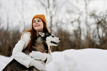 woman in the snow playing with a dog fun friendship fresh air - obrazy, fototapety, plakaty
