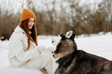cheerful woman outdoors in a field in winter walking with a dog Lifestyle - obrazy, fototapety, plakaty
