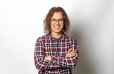 Portrait of a smiling young man on a white background. Happy guy student with arms crossed on his chest.Portrait of a smiling young man in a shirt on a white background. Happy guy student with a styli