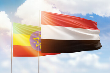 Sunny blue sky and flags of yemen and ethiopia