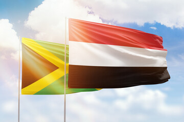 Sunny blue sky and flags of yemen and jamaica