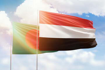 Sunny blue sky and flags of yemen and bangladesh