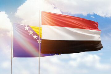 Sunny blue sky and flags of yemen and bosnia