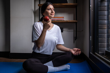 healthy lifestyle, woman doing yoga at home and eating apple, healthy lifestyle, home environment