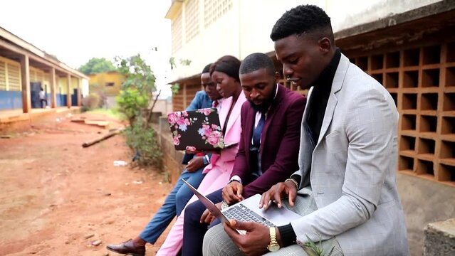 Young african business people discuss sitting using laptops, well dressed people.
