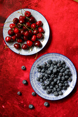 Vivid still life with summer berries on a table. Textured background with copy space. Fresh organic fruit on a table. Eating healthy concept. 