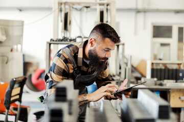 An industry worker checking on bus construction in vehicle production factory.