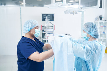 Surgeon assistant helping him in the operation room