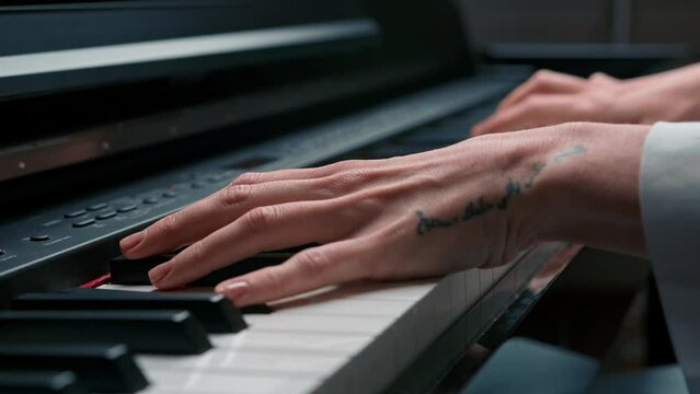 Selective focus to piano key and fingers to play the piano. There are musical instrument for concert or learning music. Close up hand of child musician playing the piano on stage.
