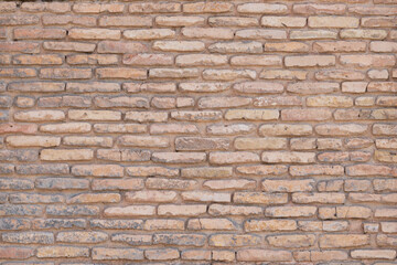 Fragment of a wall made of clay bricks.