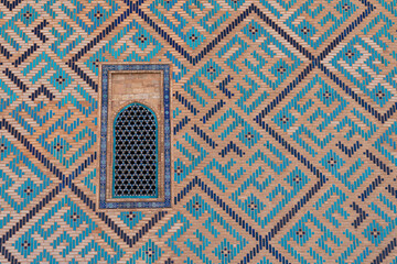 Obraz premium Fragment of a mosaic wall of a Central Asian mosque with a window.