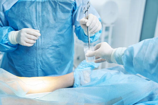 Surgeon picking up cotton wool during the operation