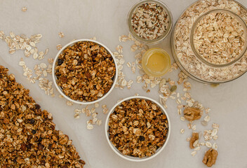 Homemade granola with ingredients in jars, cereal, honey nuts and seeds and 