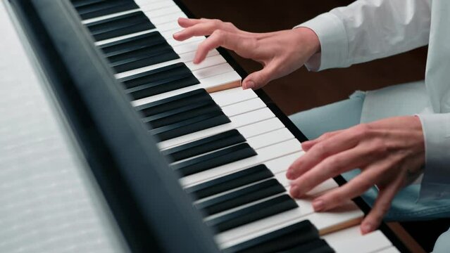 Close-up: a woman sensually plays the piano