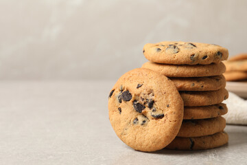 Tasty chocolate chip cookies on grey table. Space for text