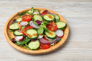 Tasty salad with different vegetables on wooden table