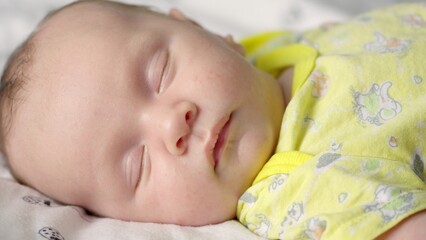 Infant sleeping at home. Small baby sleeping. Close-up shot of infant sleeping. Macro shot of a small caucasian baby resting. Cinematic shot of napping child..