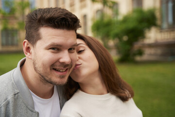 Fototapeta premium Woman in love kissing man cheek on the street