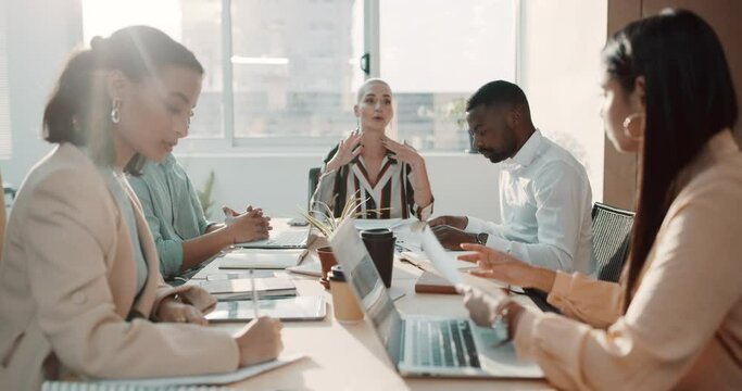 Ambitious colleagues analysing reports and documents while planning and brainstorming strategies in startup agency. Diverse group of businesspeople passing paperwork during meeting in office boardroom