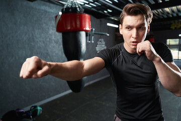 Athletic young man shadow-boxing during gym workout