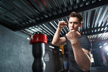 Naklejka premium Sportsman shadow-boxing during training session at gym