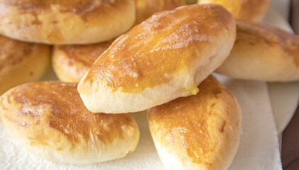 Lots of delicious freshly baked hot pies with stuffing, food background, close-up, Russian cuisine