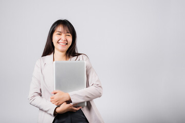 Fototapeta premium Front view woman smiling confident smiling holding closed laptop, Portrait excited happy Asian young female person hugging close cover computer device studio shot isolated on white background