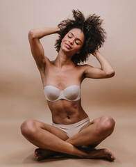 Closeup of a smiling young Latin afro woman. Joy, positive and love. Beautiful african-style hair. Pastel studio background.