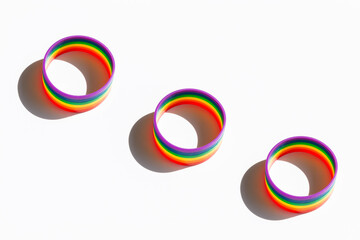 Pride rainbow awareness wristbands on white background.