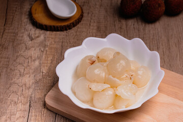 Lychee in sweet syrup in white cup. Summer snack.