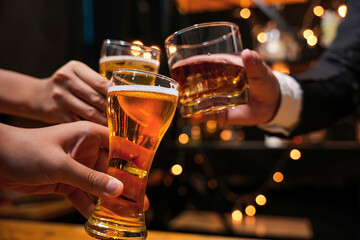 food and drink male friends are happy drinking beer and clinking glasses at a bar or pub.