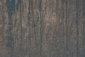 The texture of an old dirty dark-colored wall
